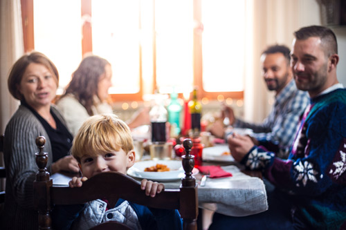 ChildSittingAtTableHappyEatingFamilyHoliday2.jpg